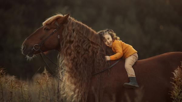 Free smiley cute little girl is sitting on brown horse wearing yellow dress in forest background hd cute wallpaper download