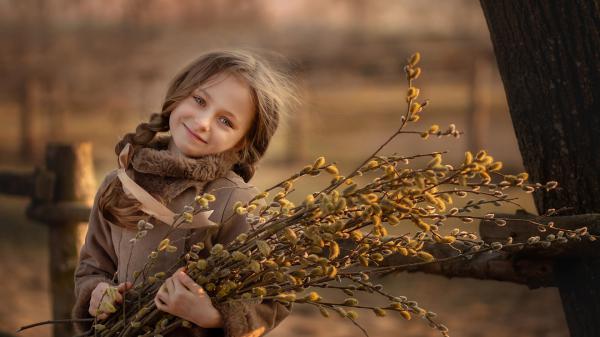 Free smiley cute little girl is wearing brown dress and holding bundle of yellow plants hd cute wallpaper download