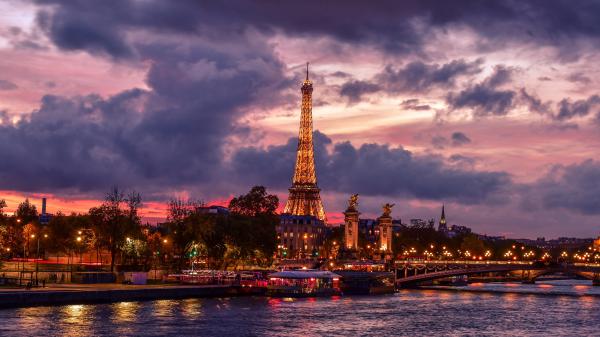 Free yellow lighting eiffel tower paris with background of gray and purple clouds during evening time hd travel wallpaper download